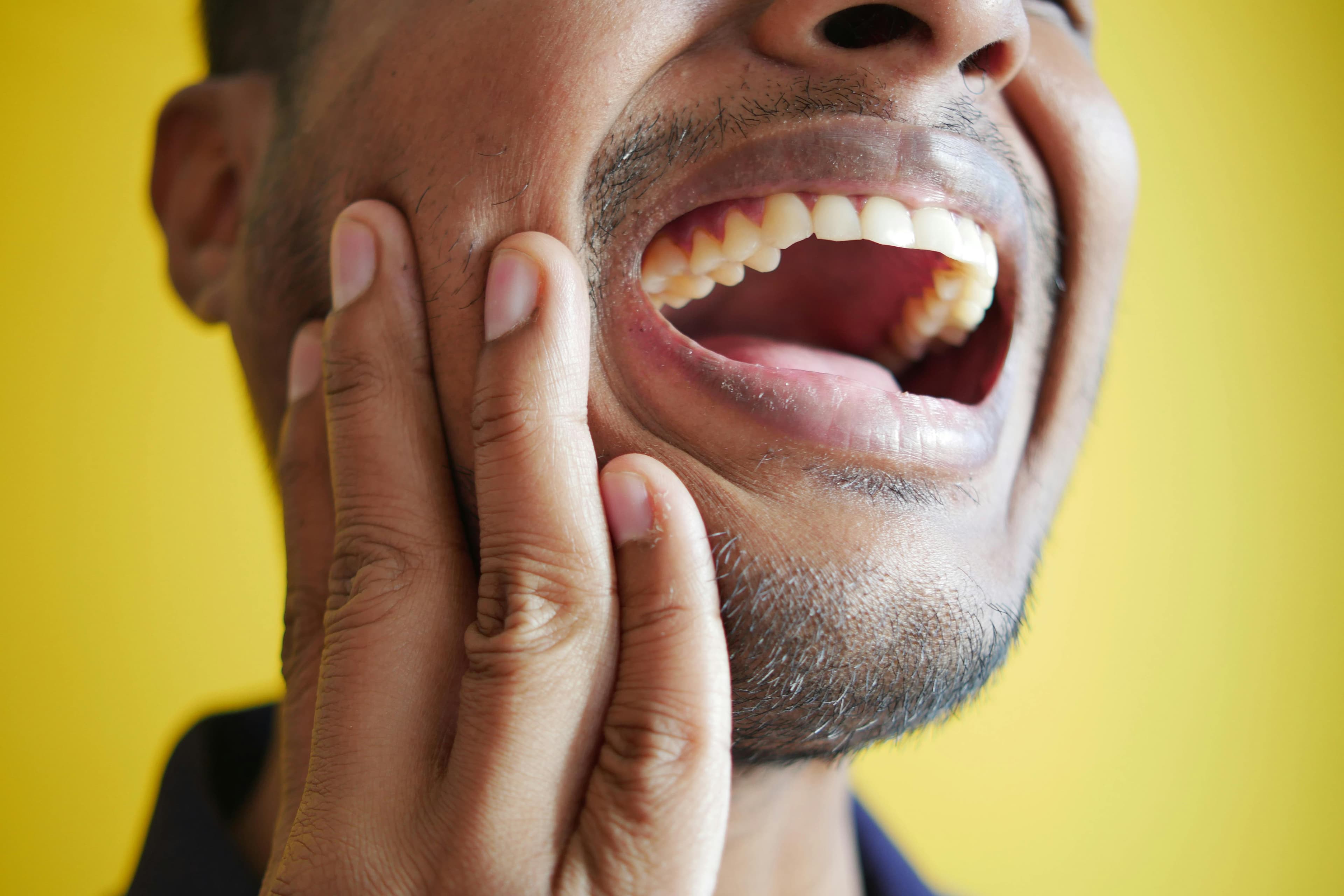 person holding jaw in pain