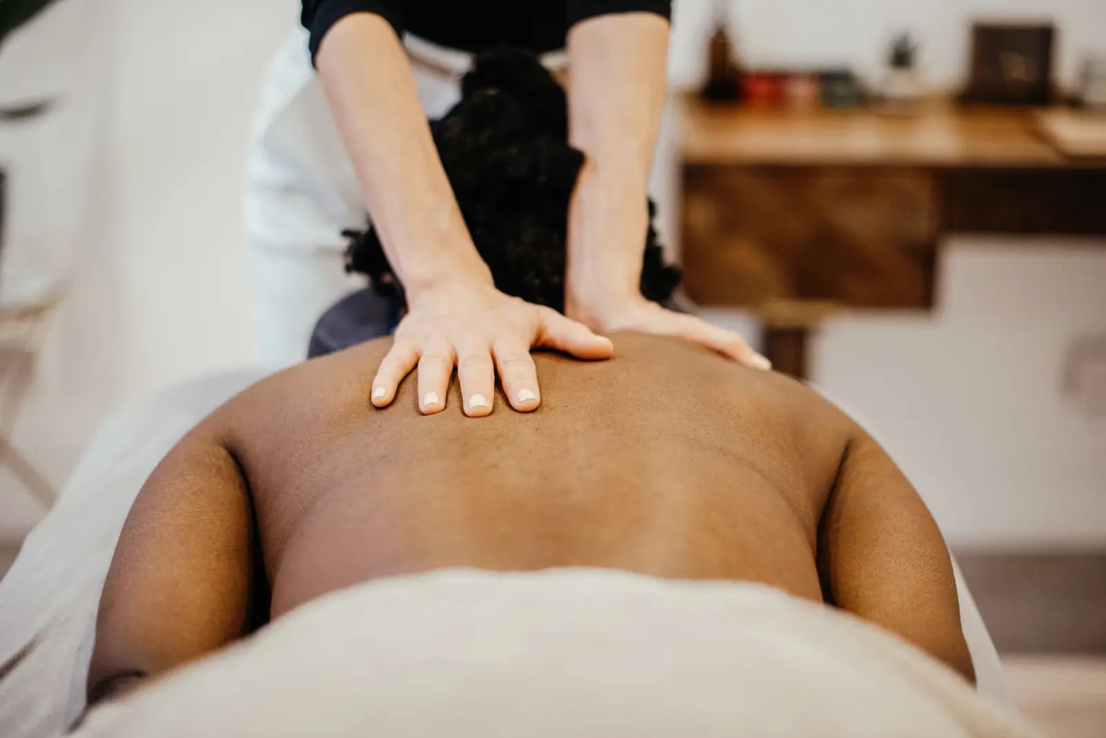 Therapist giving a back, neck, and shoulder massage for muscle relief.